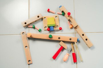 children hands playing with colorful wooden constructor puzzle bricks