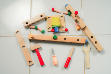 children hands playing with colorful wooden constructor puzzle bricks