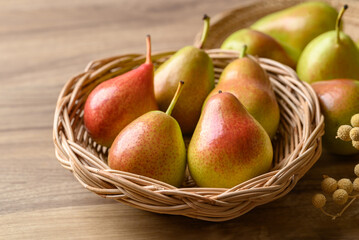 Fresh pear fruit in natural basket on wooden background, Healthy fruit