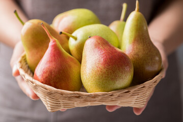 Pear fruit in basket holding by woman hand, Healthy eating