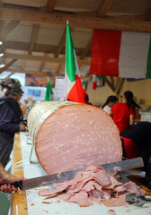 Giant mortadella sliced with a long knife during the town festival