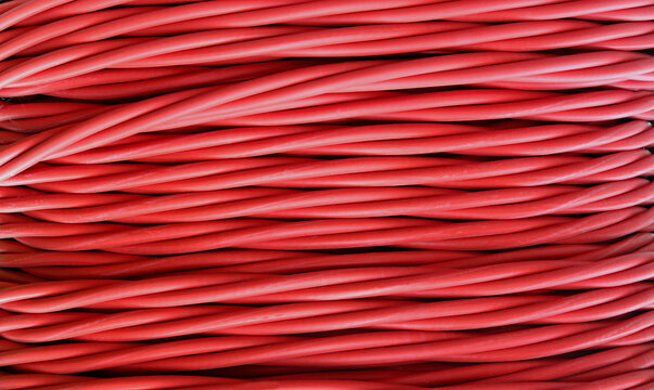 High voltage power line with red insulated cable against a background