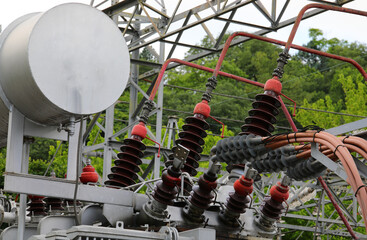 power transformer at a power plant with high-voltage connectors and cables and a cooling oil tank