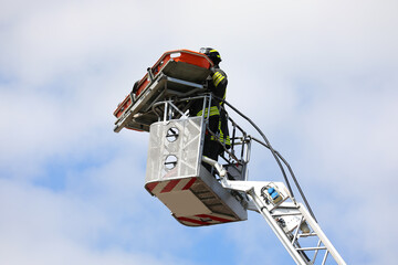 Firefighters on board an aerial platform with stretcher during the rescue of the injured person