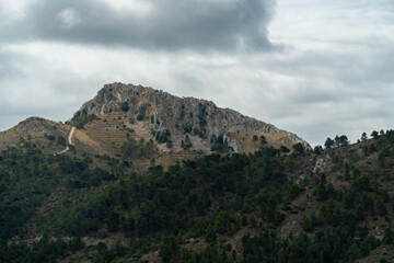 Beautiful landscape with a rocky mountain on background, on a cloudy day.