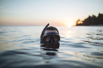 Diver submerged into water up to his mask