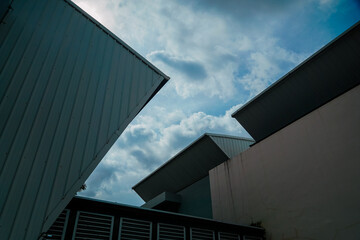 A building with a slanted roof and a cloudy sky