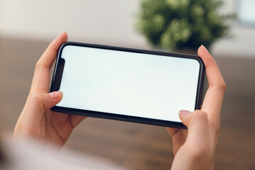 Hand holding smartphone mockup of blank screen for graphic display montage.