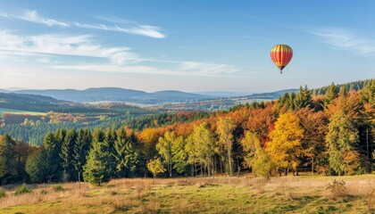 Obraz premium Magical Autumn Scene: Hot Air Balloon Over Pilgramsberg in Bavarian Forest