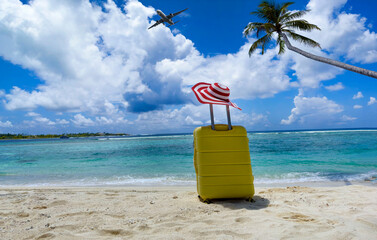 The yellow luggage on the beach- summer travel concept