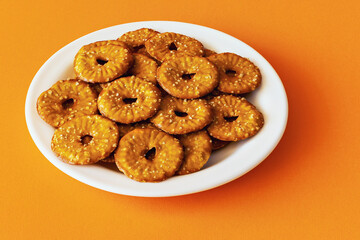 Round crackers with a hole and salt on an orange background