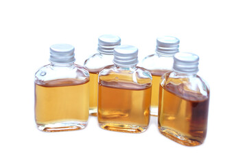 Transparent glass bottles of homemade herbal massage oil. Concept, Thai local wisdom to use fragrant medicinal herbs to make  massage oil for aromatherapy and relaxation.         