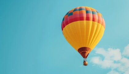 Naklejka premium A Vibrant Journey: A Yellow and Red Hot Air Balloon Soaring Through the Blue Sky