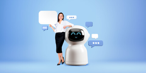 Businesswoman showing mock up speech bubble, standing near smiling robot