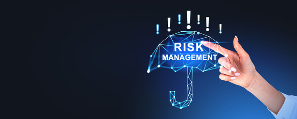 Hand pointing at illuminated umbrella icon with risk management text, on a dark background. Concept...