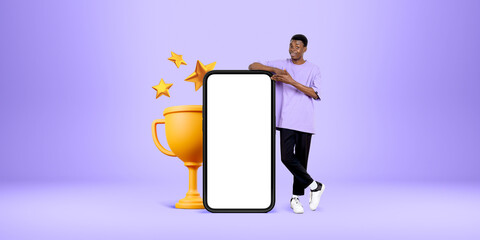 Black man hand point at mockup smartphone and champion cup, success concept