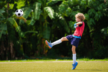 Child playing football. Kids play soccer.