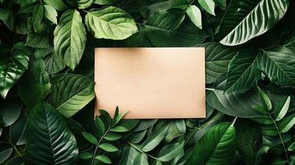 Brown blank paper sheet on various green tropical leaves background creating a natural frame. Ideal for eco-friendly or nature-themed projects.