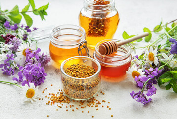 Raw organic bee pollen and honey in jars.