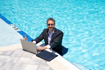 Outdoor business. Businessman tourist in suit rest on beach with laptop outdoor. Business man...