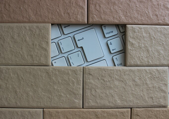White Computer Keyboard Under Tiles Brickwork. Concept Photo For Computer Protection Illustration 

