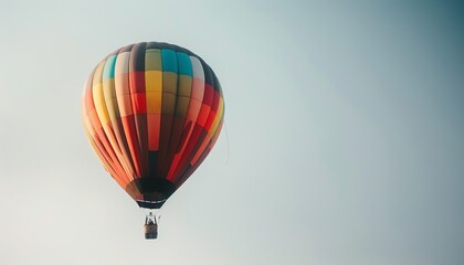 Fototapeta premium Winter Wonderland: Vibrant Hot Air Balloon Soaring in the Grey Sky at Aerostat Festival