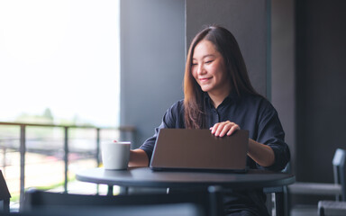 Portrait image of a woman opening or closing laptop computer, getting ready for work, finished work...