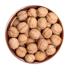 Walnuts in their shells, in a brown bowl. Unshelled dried seeds of the common walnut tree Juglans regia. Whole nuts with shells, used as snack, for baking and as decoration. Isolated from above. Photo