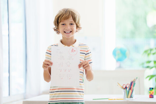 Child holding school test with excellent A grade.