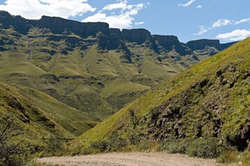 Driving view from Sani Pass (2,876 meters) to the rock formations of the Twelve Apostles in the Drakensberg Mountains and the landscape of KwaZulu-Nathal province. Republic of South Africa. Africa.