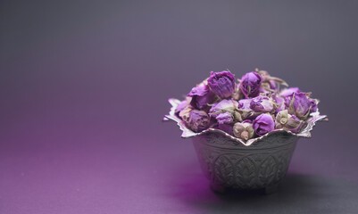 Dried damask rose buds in a silver dish