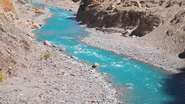 Closeup shot of blue colored Tsarap Chu river flowing in the remote areas of Zanskar as seen during the trek to Phugtal Gompa in Zanskar Valley, Ladakh, India. Blue colored river flowing in Himalayas.