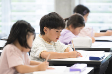 Elementary school children studying in an elementary school or cram school classroom Taking tests and exams