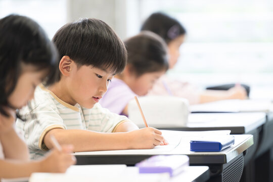 小学校や塾の教室で勉強する小学生の子供たち　テストや試験を受ける