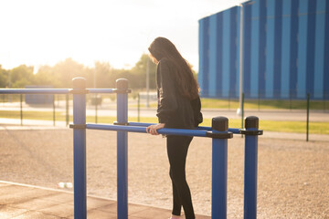 Woman Working Out on Parallel Bars at outdoor Public Park during sunset