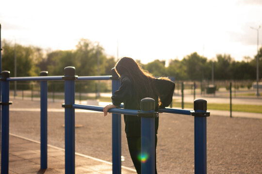 Woman Working Out on Parallel Bars at outdoor Public Park during sunset