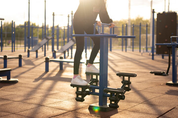 Female person Exercising on Stepper at Outdoor Fitness Park in the Evening, sport workout