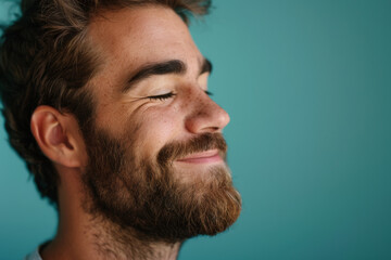 Obraz premium A close up of a man with beard and closed eyes looking to a side
