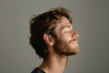 Obraz premium A close up of a man with beard and closed eyes looking to a side