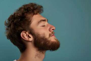 Fototapeta premium A close up of a man with beard and closed eyes looking to a side