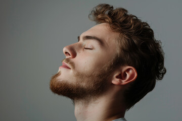 Fototapeta premium A close up of a man with beard and closed eyes looking to a side