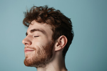 Fototapeta premium A close up of a man with beard and closed eyes looking to a side
