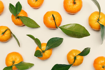 Bright, fresh tangerines with green leaves on neutral background, minimal aesthetic citrus fruits pattern, healthy organic texture orange colored mandarin top view, life stile food