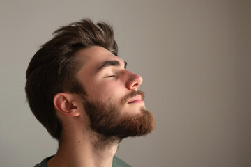 Obraz premium A close up of a man with beard and closed eyes looking to a side