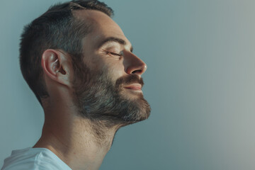 Obraz premium A close up of a man with beard and closed eyes looking to a side