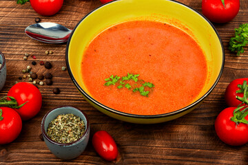 Vegetable tomato soup on a wooden table.