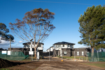 The construction site features rows of modern residential townhouses in Australia. Concept of real estate development, the housing market, homes in the suburb, and property investment.