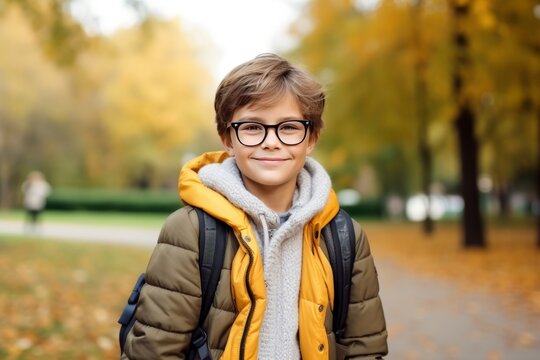 Smiling Boy with Backpack in Autumn Park