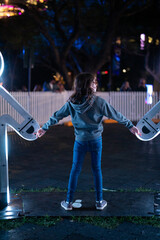 Bright lights young cacuasian girl child blue holding hands neon body figures
