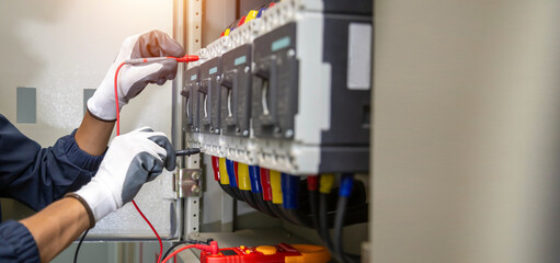 Electrician engineer uses a multimeter to test the electrical installation and power line current...